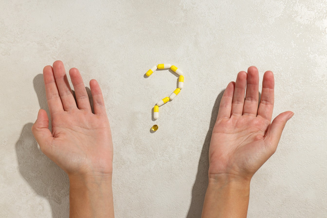 Question mark made of pills on a white background